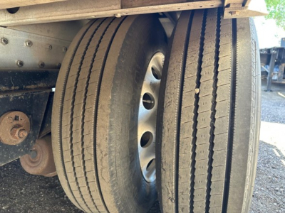 Rear view of a 2018 Reitnouer all aluminum drop deck trailer, dual rear wheels with hub, dual tires, and part of the frame; visible components include wheel rims, bolts, and a rust-colored bracket.