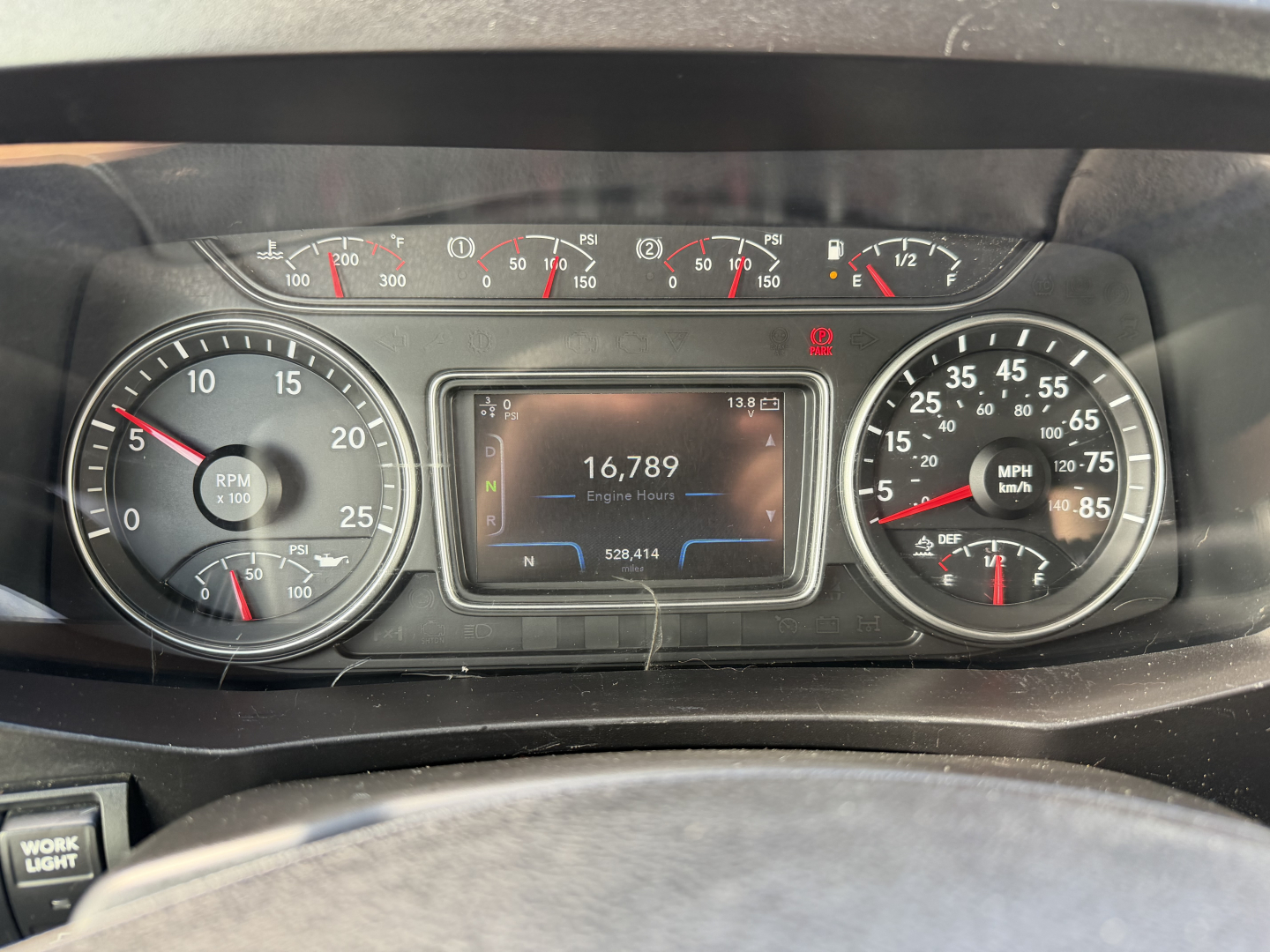 Dashboard of a 2021 International LT625 showing instrument cluster with tachometer, speedometer, fuel gauge, and central digital readout reading 16,789 engine hours.