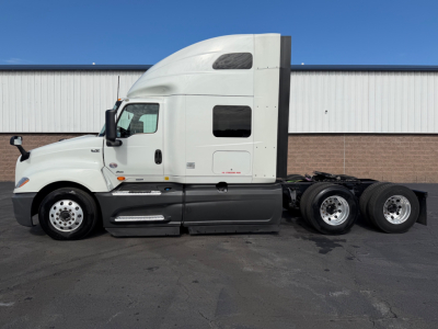 2021 International LT625 conventional sleeper tractor in white, side view showing cab and rear axles.