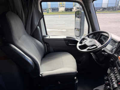 Interior of a 2021 International LT625 truck cab showing driver seat, steering wheel, and dashboard with controls.