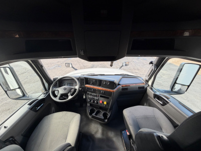 Interior view of a 2021 International LT625 truck cab showing steering wheel, dashboard with controls, center console, and driver and passenger seats.