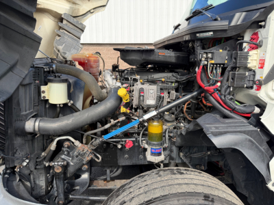 Truck engine bay of a 2021 International LT625 showing engine components, hoses, and a yellow oil filter; visible labels and wiring harnesses.