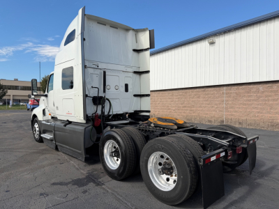 Truck chassis and cab view showing dual rear axles and fifth-wheel area. Side text on cab is not clearly legible.
