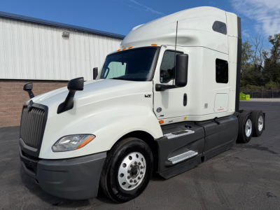 White International LT series truck cab with sleeper, front-left view showing side steps, door, and wheel. No visible logos or text legible on vehicle from this angle.