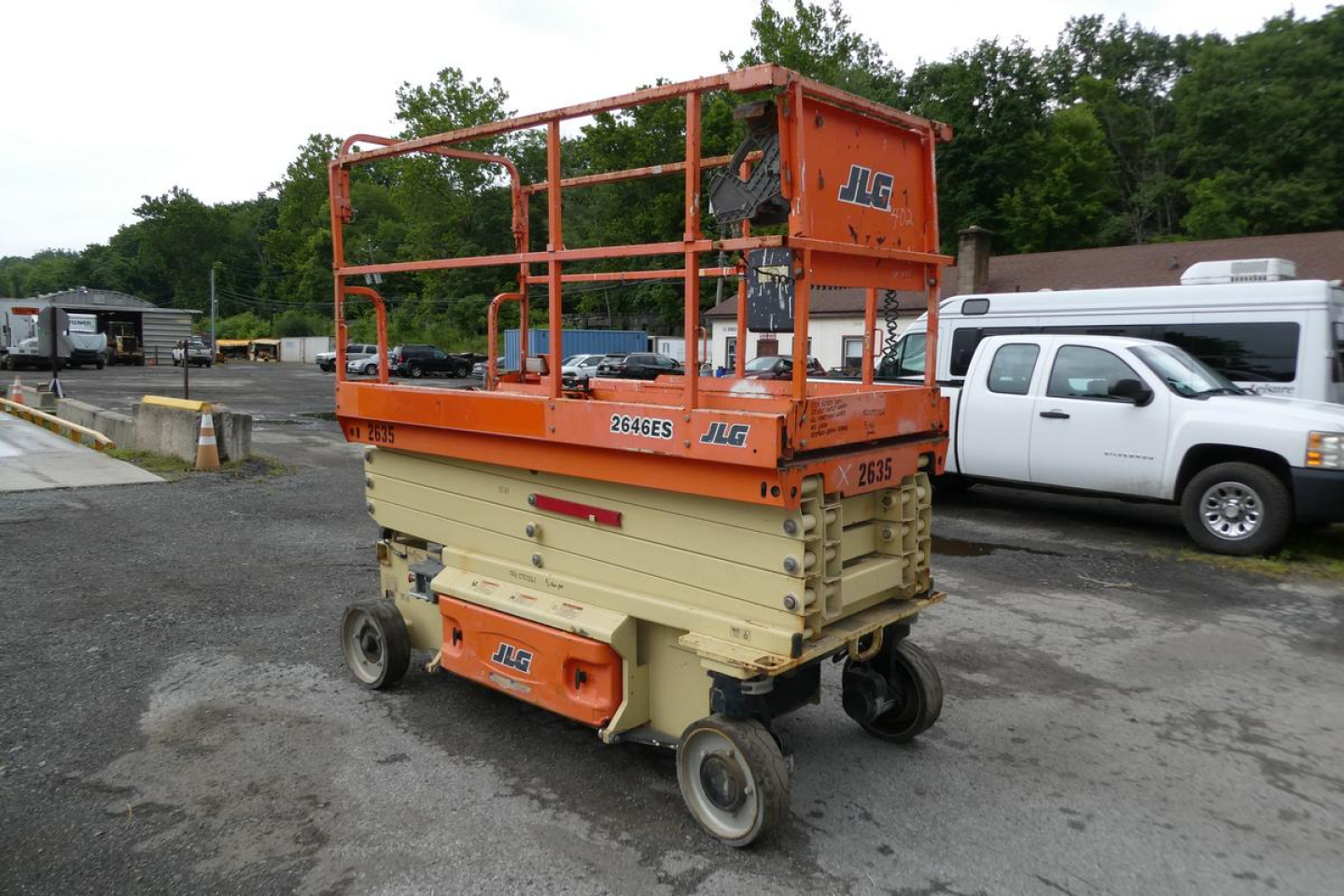 JLG 2646ES scissor lift in orange and beige colors with guard rails, side view showing JLG branding and model number 2646ES.