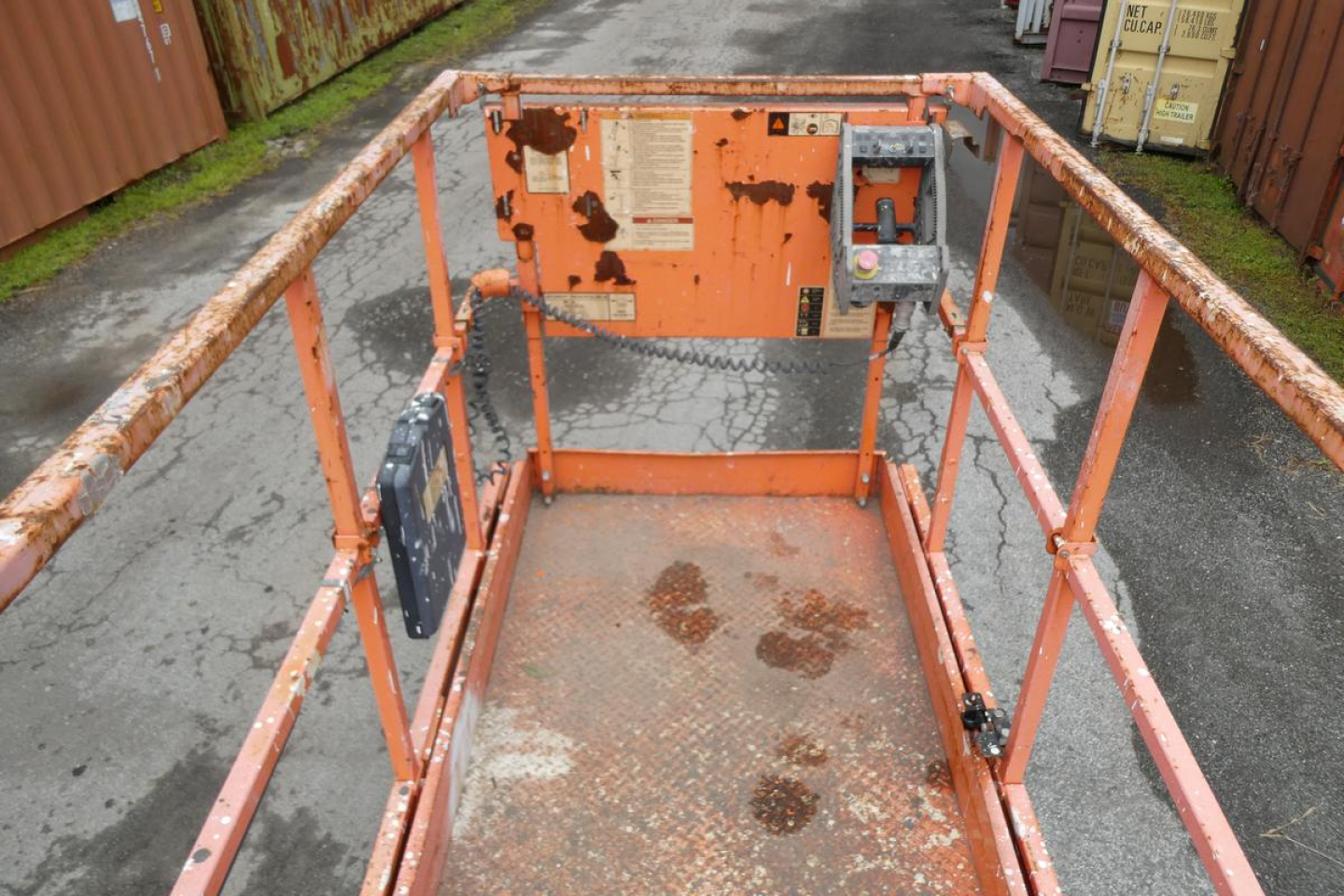 JLG 2646ES scissor lift platform deck with orange frame and guardrails, worn surfaces and control panel visible