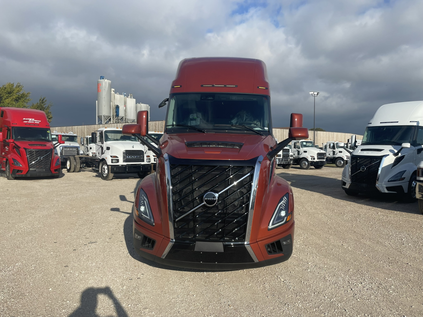 Volvo VNL64T860 truck front view showing bold grille and headlights in a truck lot.
