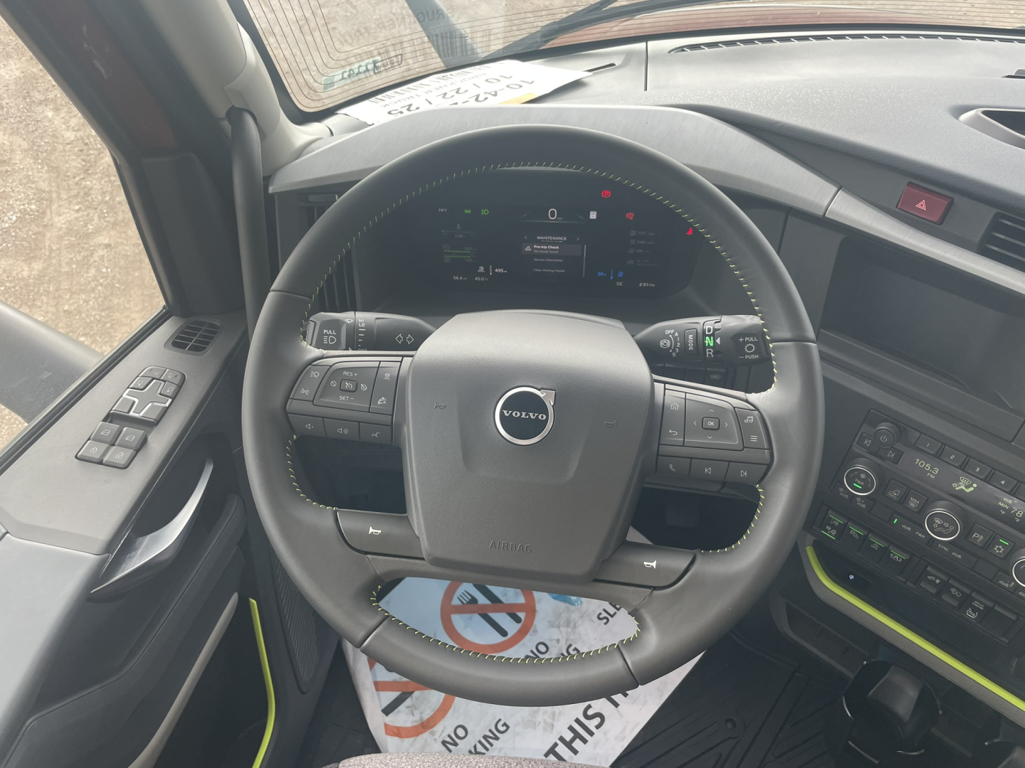 Volvo VNL64T860 truck interior steering wheel and dashboard showing digital gauge cluster and control panels.