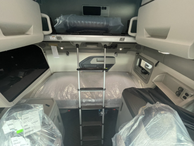 Volvo VNL cabin interior showing bunk area, ladder, and storage compartments with plastic coverings.