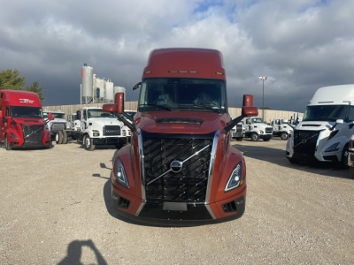 Volvo VNL64T860 truck front view showing bold grille and headlights in a truck lot.