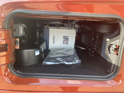 Volvo VNL64T860 sleeper cab front storage with Xantrex power inverter and installed components in rear storage compartment.