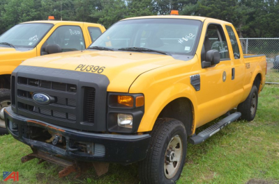 2009 Ford F-250 Super Duty extended cab pickup truck in yellow with black grille; front bumper missing; large side mirrors; step rails visible; truck appears used.