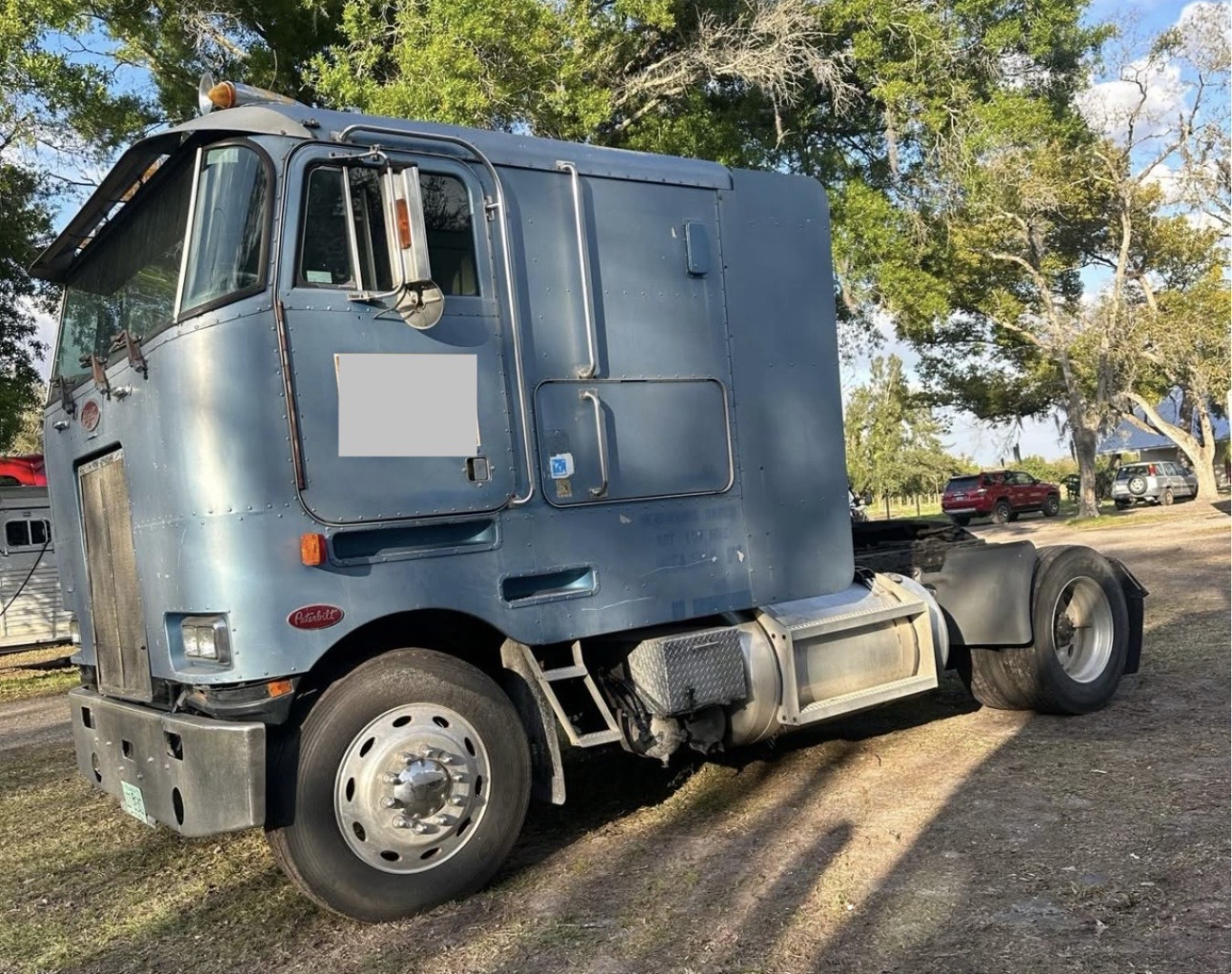 Peterbilt 362 cabover truck in blue, side view showing cab, sleeper area, and rear drive chassis with fuel tanks.