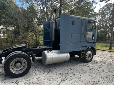 Peterbilt 362 cabover truck side view showing fuel tank and rear chassis with cab mounted, light blue paint, no visible branding text.