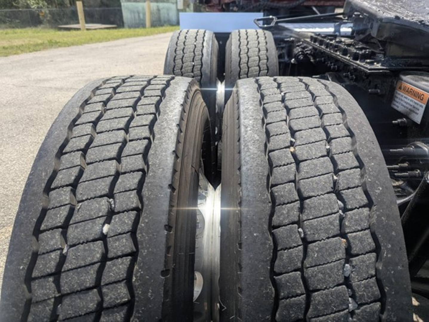Freightliner Cascadia 126 showing heavy dual rear tires and wheel rims with tread visible.