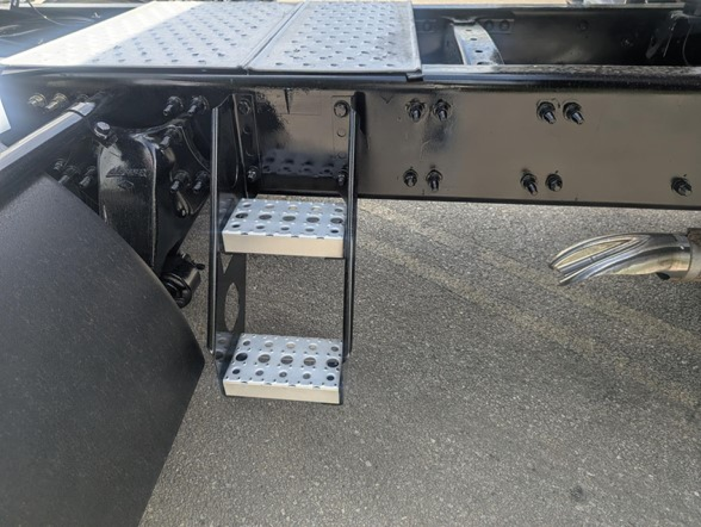 Freightliner Cascadia 126 side view showing metal undercarriage steps and chassis railing.