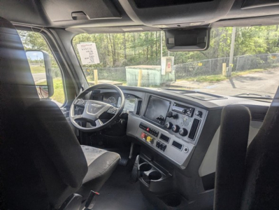 Cab interior of 2022 Freightliner Cascadia 126 with steering wheel, dashboard, and center console in view.