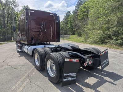 Freightliner Cascadia 126 tractor rear view showing dual rear axles and fifth wheel, black chassis, mud flaps with SelectTrucks logo.