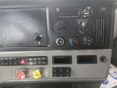 Dashboard panel of a Freightliner Cascadia cab showing climate controls, hazard button, two knobs, and a blank panel with empty slots.