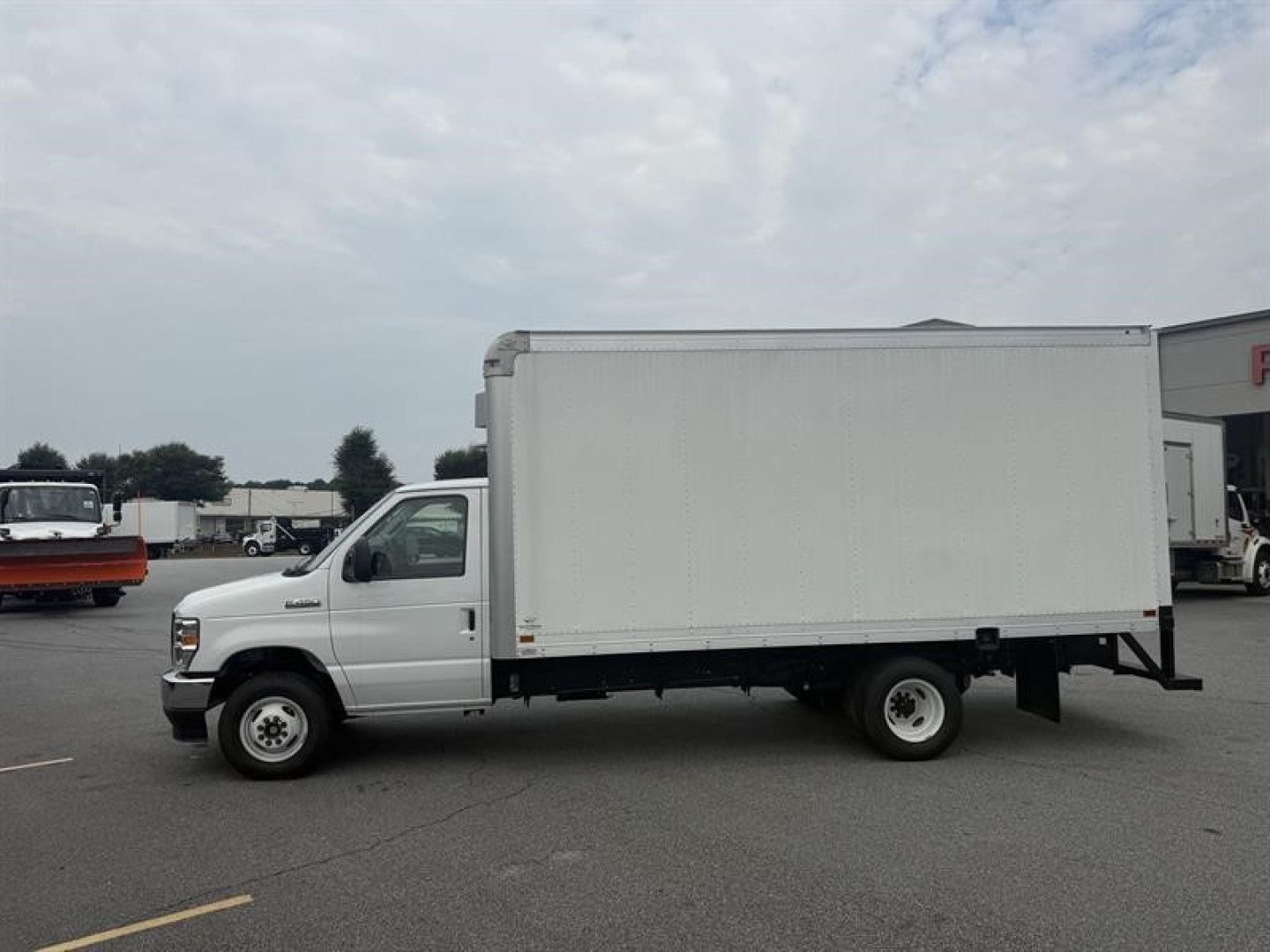 White 2027 Ford E450 box truck in a parking lot, side view showing cargo box and cab; no visible brand decals on the box.