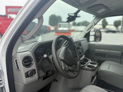 Ford E-450 interior cab view showing steering wheel and dashboard with cup holders and center console.