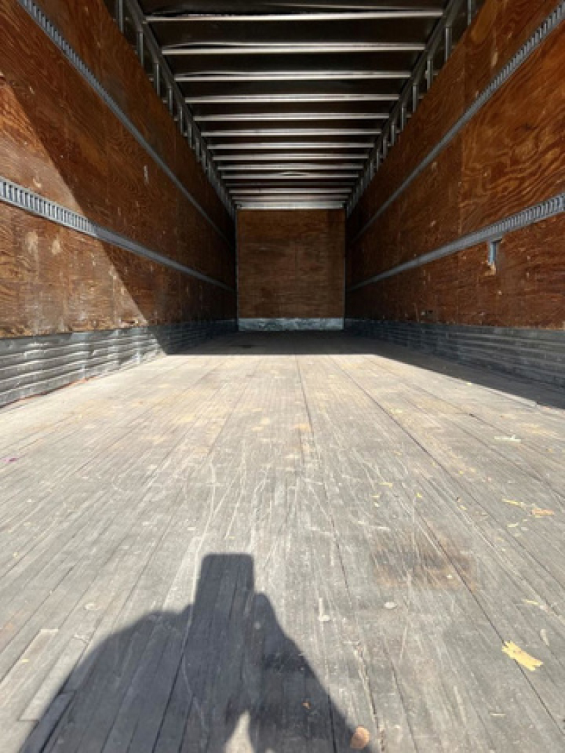 Trailer interior showing wooden side walls and metal framing with empty cargo area.