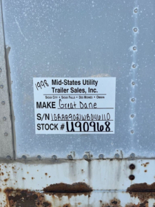Sticker on trailer showing Make: Great Dane, S/N: 1GRAA9021WB046110, Stock # U90968, from Mid-States Utility Trailer Sales, Inc. in a metal trailer wall with rust at the bottom