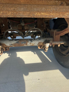Underbody view of a used Great Dane van trailer showing rusted frame, suspension, and wheel assembly