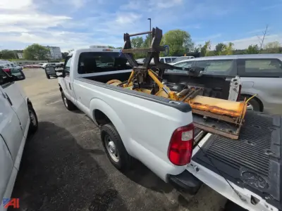 Ford F-250 Super Duty pickup with utility crane in bed and hitch attachment, white extended cab, 4x4, rear view showing tailgate and cargo.