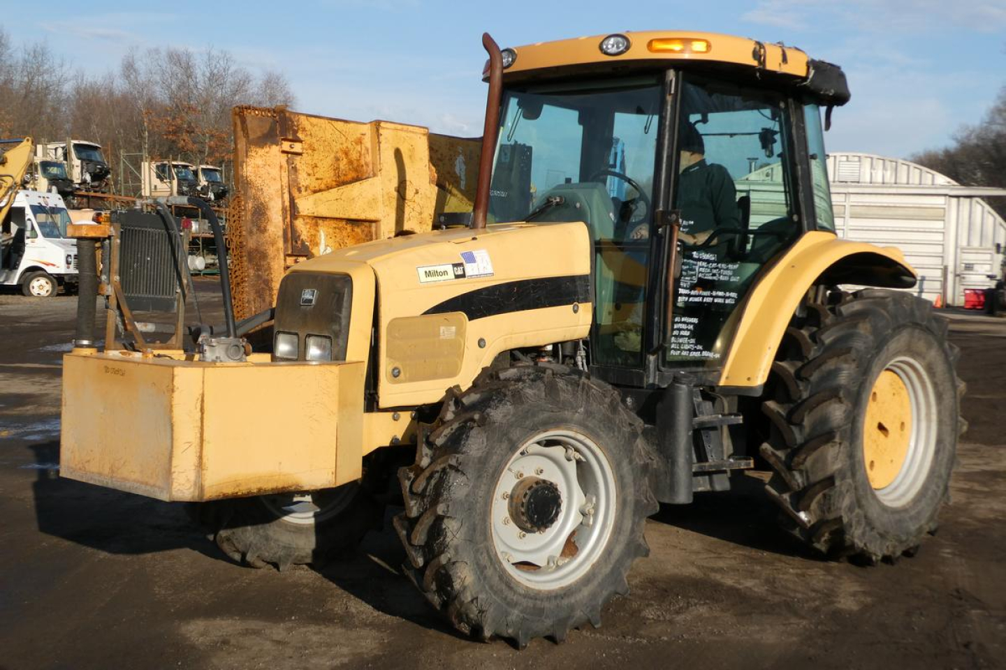 Kubota Challenger MT455B tractor in-service showing side view, enclosed cab, large rear tires, front loader attachment, yellow and black paint with operator seat inside cab.