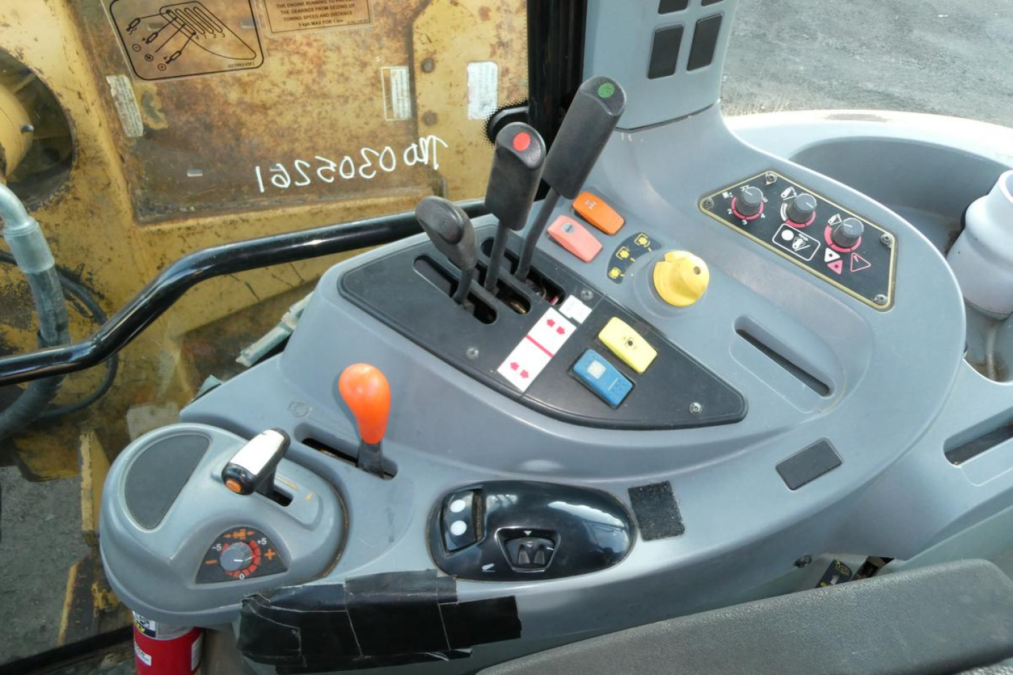 Operator cab control panel in a Challenger MT455B tractor showing multiple levers, switches, and a joystick with colored buttons.