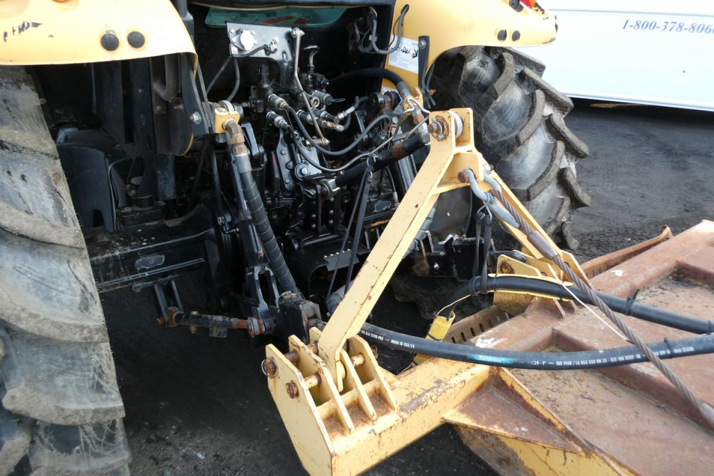 Challenger MT455B tractor rear with hydraulic hoses and hitch attachment; visible tires and front implement supports.