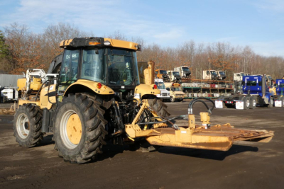 John Deere Challenger MT455B tractor with front-mounted mower/loader attachment in a yard.