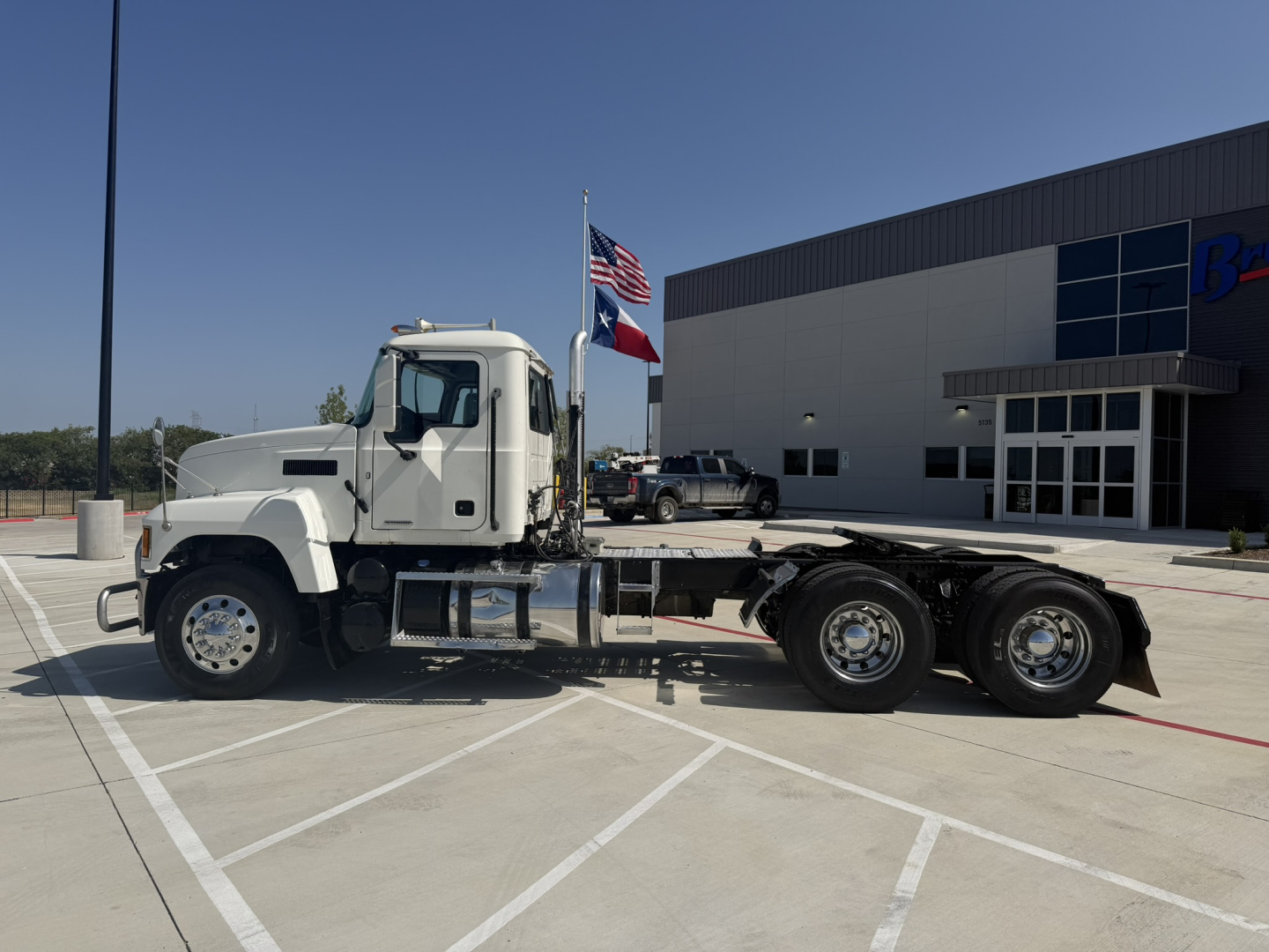 2020 Mack PI64T conventional daycab truck side view showing single sleeper cab and dual rear axles in a parking lot.