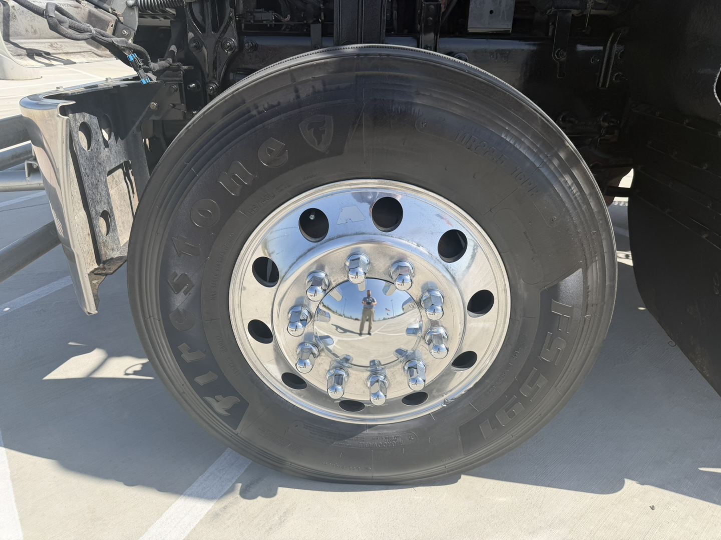 Front wheel of a 2020 Mack PI64T truck showing Goodyear tire and polished chrome wheel with lug nuts and hub cover.