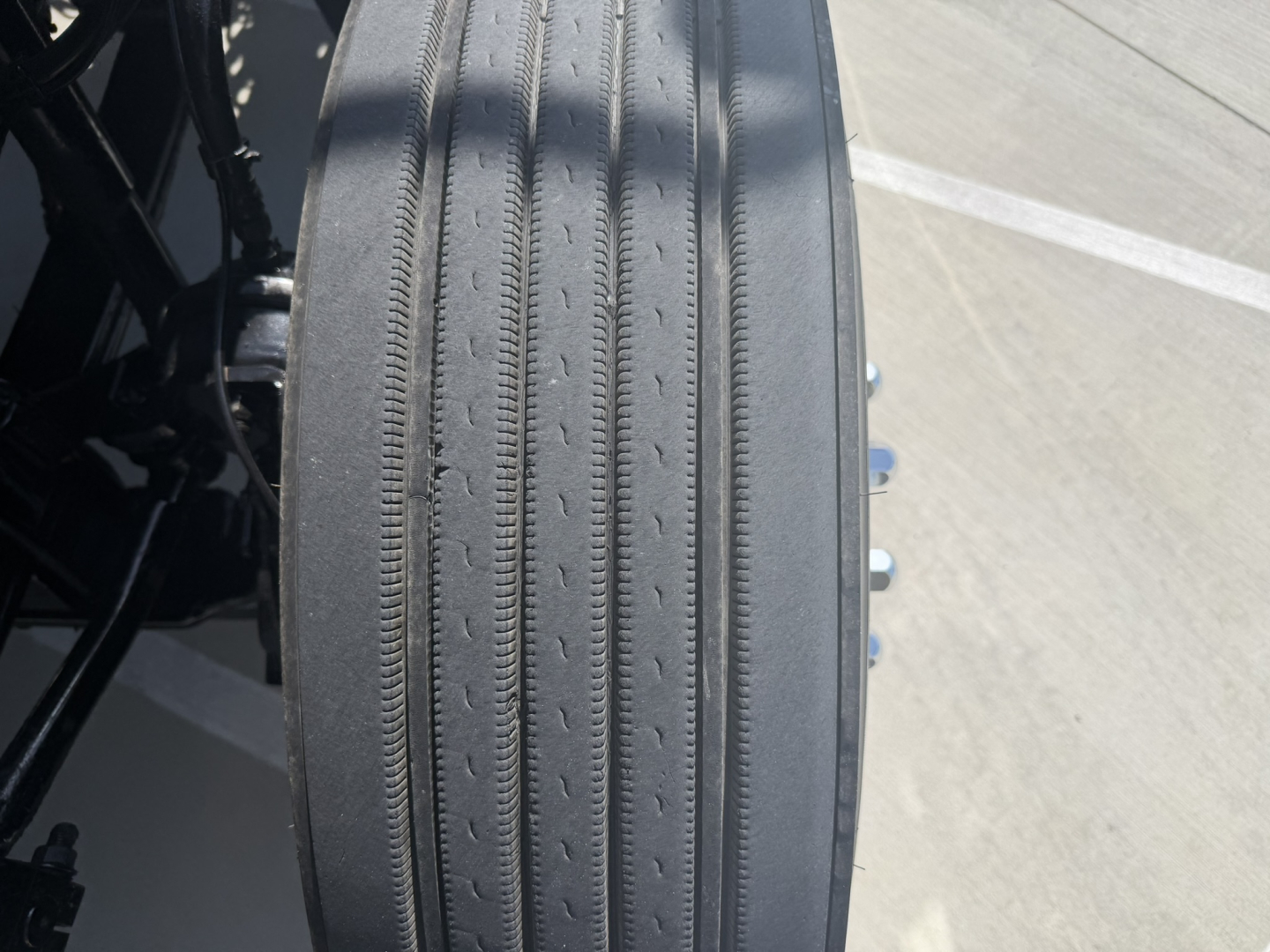 Rear view of a 2020 Mack PI64T truck wheel showing ribbed tire tread and part of the axle/underbody components.