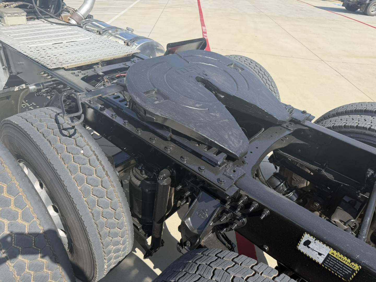 Mack PI64T truck chassis showing fifth-wheel and fuel/tank area, undercarriage and dual rear wheels, mechanical frame visible.