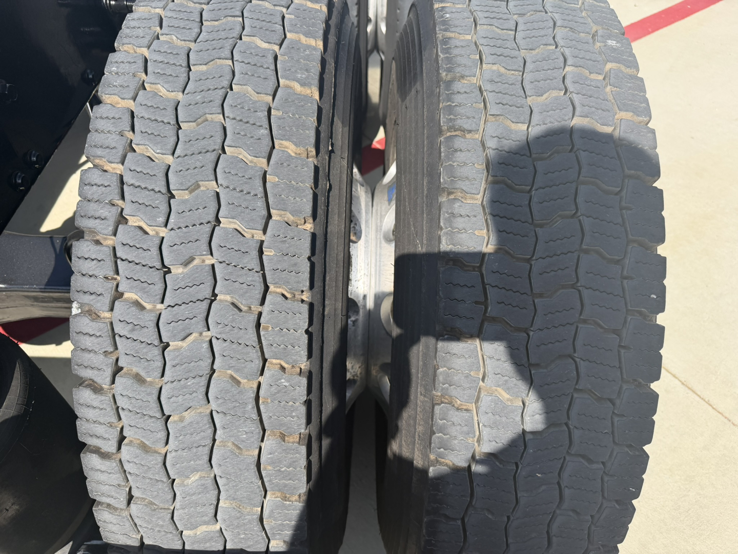 Truck dual rear tires on Mack PI64T showing tread and wheel area.