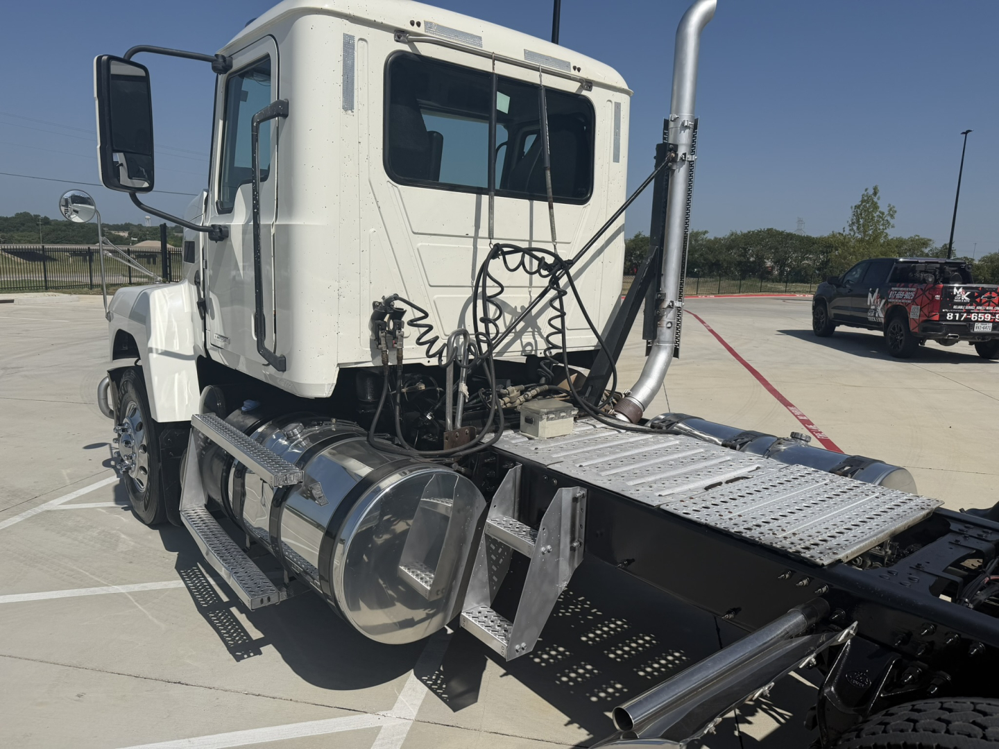 Truck cab of a 2020 Mack PI64T in-service with exposed engine bay area, steps, fuel tanks, and chassis visible.