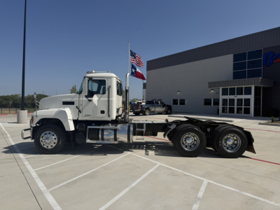 2020 Mack PI64T conventional daycab truck side view showing single sleeper cab and dual rear axles in a parking lot.