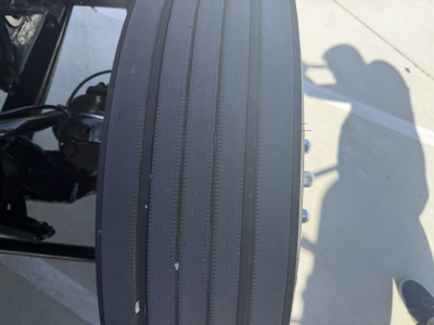 Truck component close-up showing a vertical ribbed surface on a Mack PI64T truck cab or frame area with bolts and shadow of a person