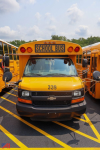 Front view of a yellow 2016 Chevrolet Thomas express mid-size school bus with number 339 and a blank CHEVROLET emblem on grille, 'SCHOOL BUS' sign above windshield.