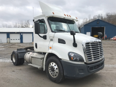 Truck cab and front section of a white Freightliner Cascadia 113 tractor seen from the driver's side, with a grille, headlights, and raised sleeper/roof air intake.