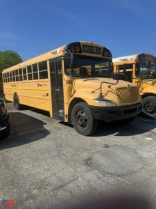 School bus in a parking lot showing CE Series IC Corporation bus with yellow exterior and 'SCHOOL BUS' sign, number 285 on the side, front grille, passenger windows.