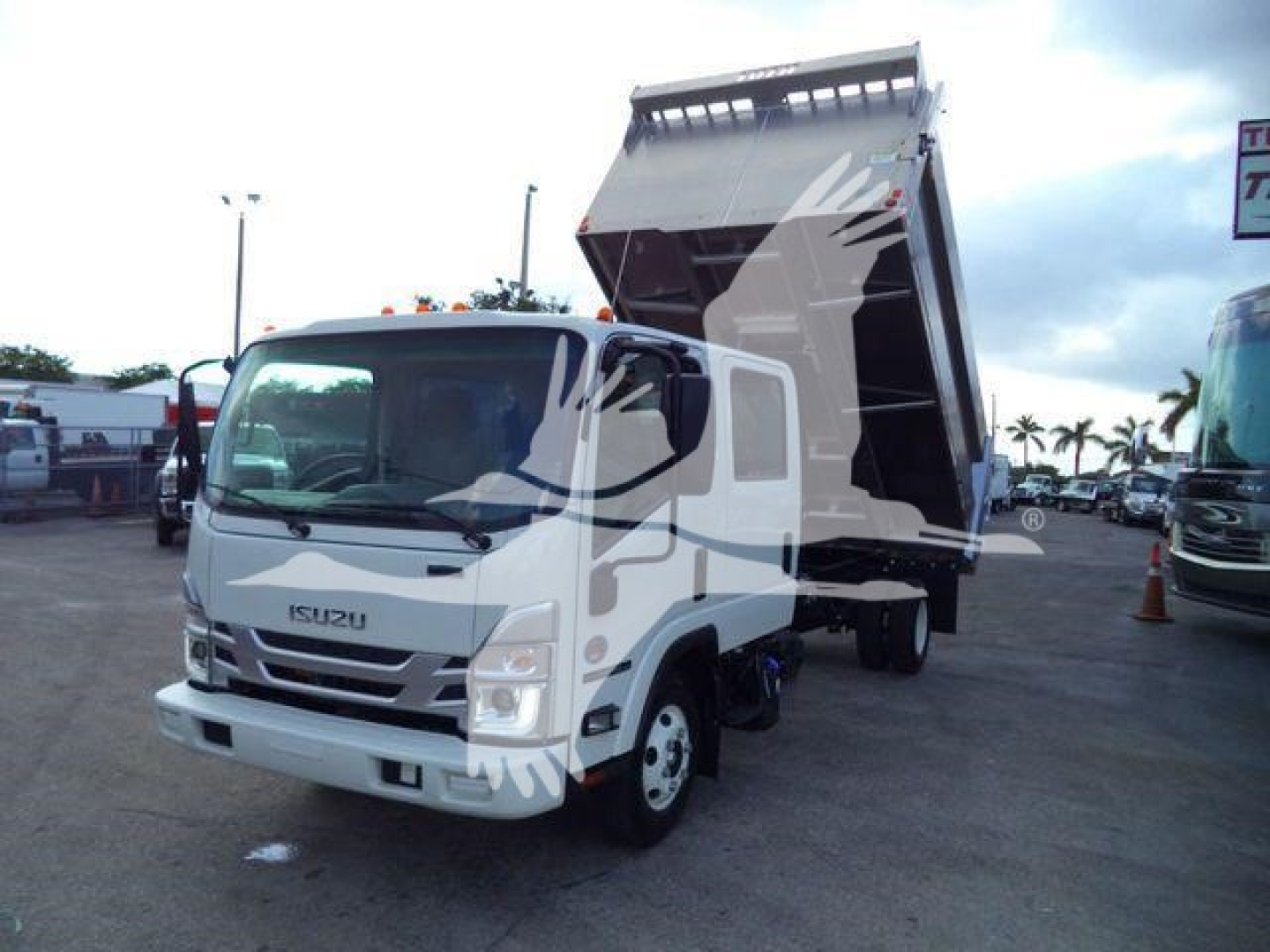 Isuzu NPR HD dump truck with raised bed in a dealership lot