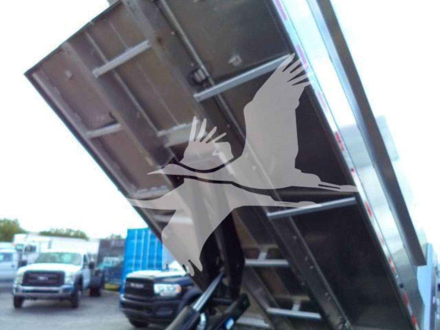 Isuzu NPR HD dump truck bed raised showing steel frame and hydraulic mechanism.