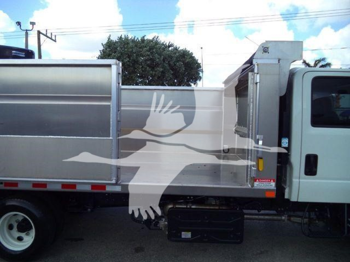 Isuzu NPR-HD dump truck side view showing aluminum dump body and cab.