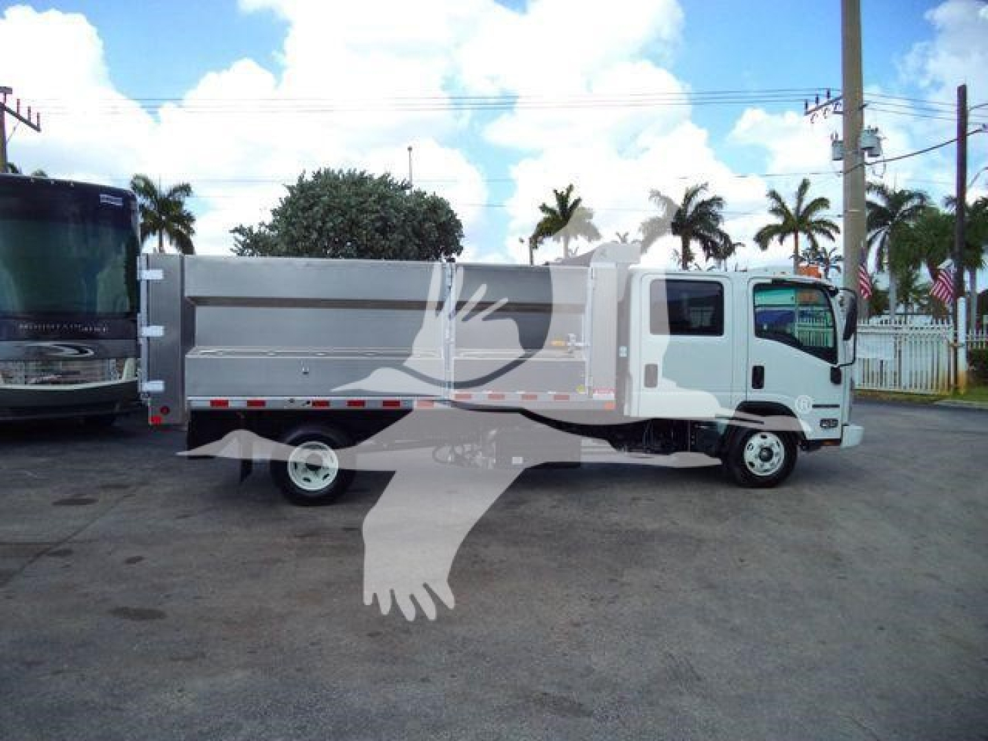 Isuzu NPR HD dump truck side view showing cargo bed and cab with white body.