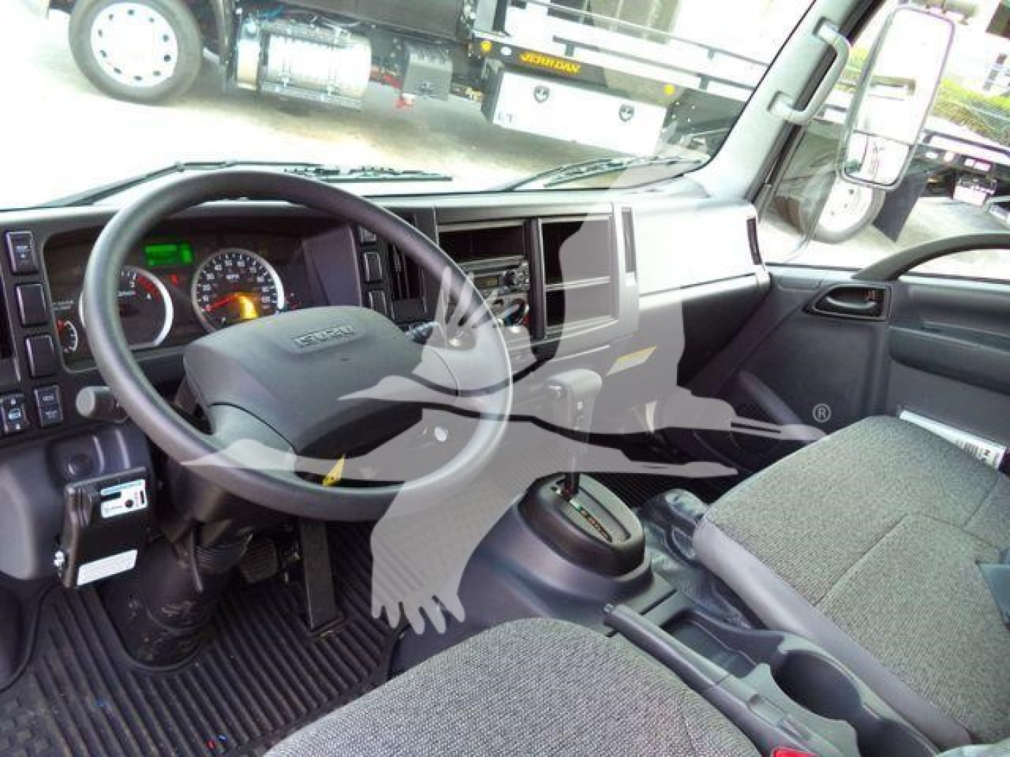Isuzu NPR HD interior showing steering wheel, dashboard, and front seats.