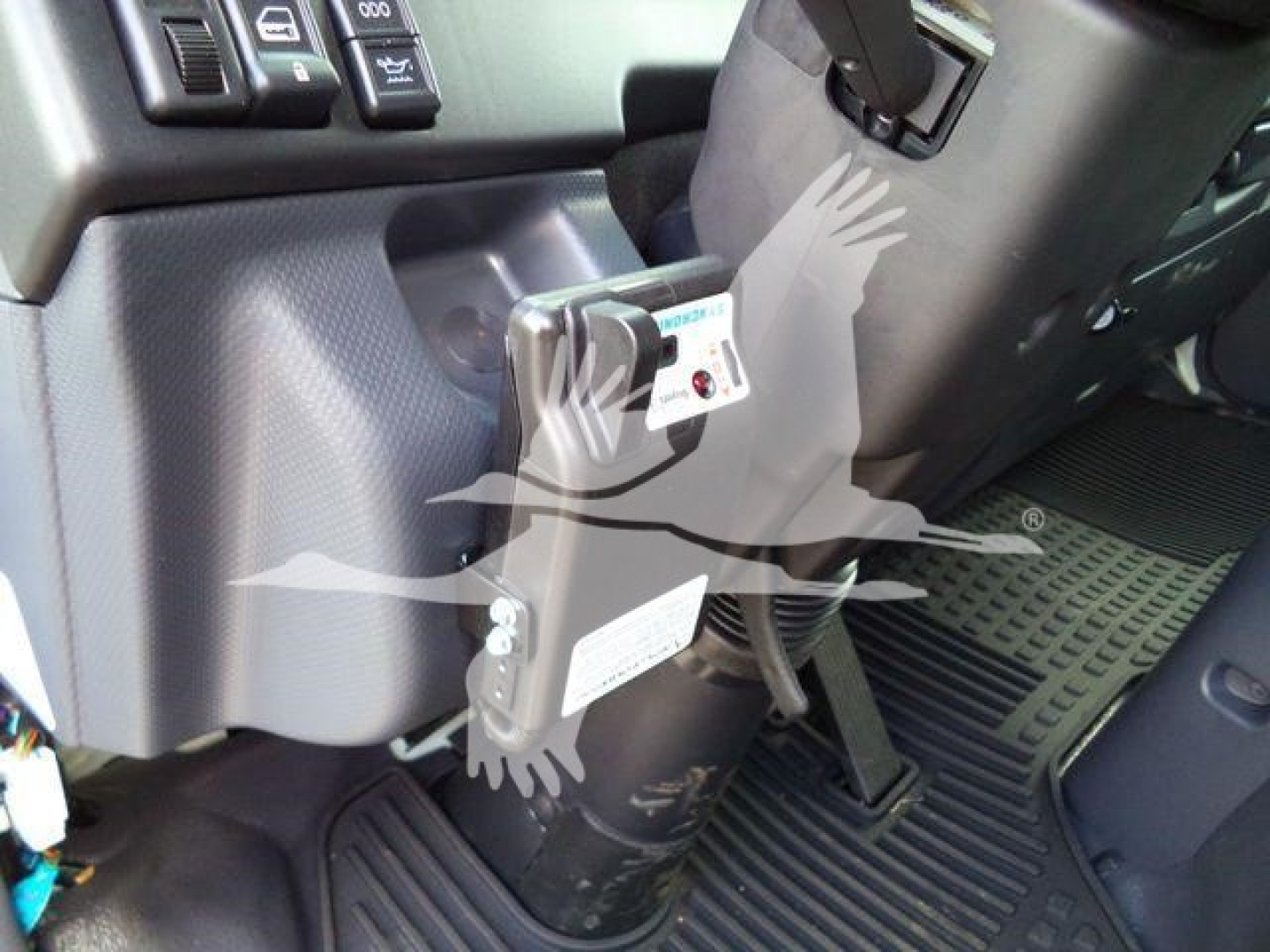 Isuzu NPR-HD dashboard area with ignition switch and control panel; visible label on a tethered device and floor mat,” showing interior components.